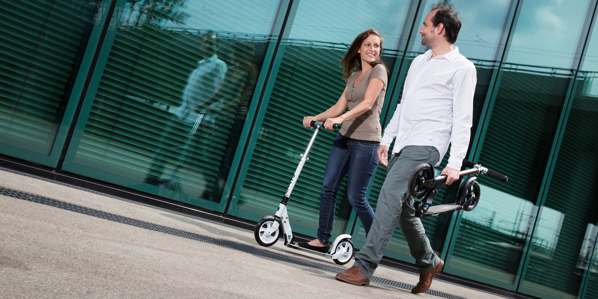 Micro White and Black kick scooter riders