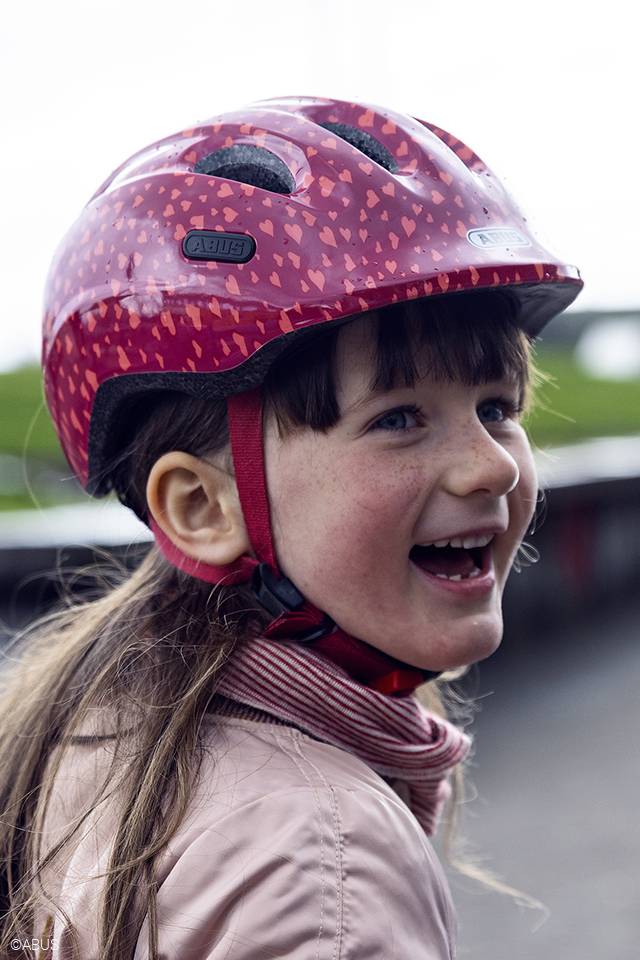 young girl wearing abus smiley 2.0 bicycle helmet in pink