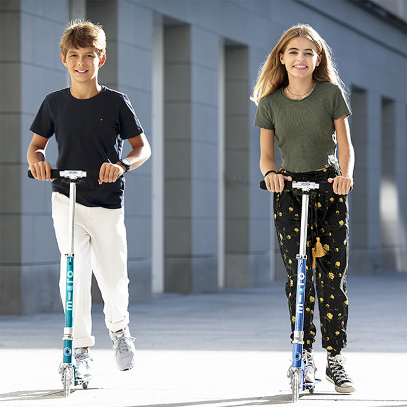 Kids riding Micro Sprite LED two wheel kick scooters