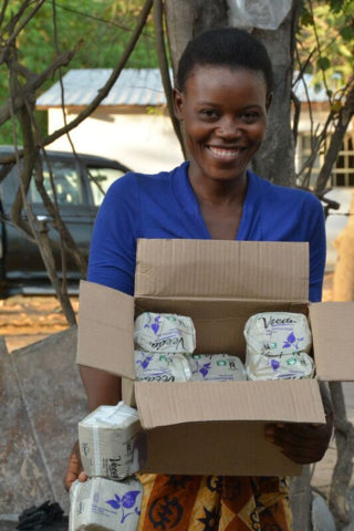 Woman holding a box filled with Veeda feminine pads