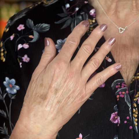 Shimmering manicure against a black floral dress