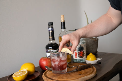garnishing chimayo cocktail with apple slice garnish