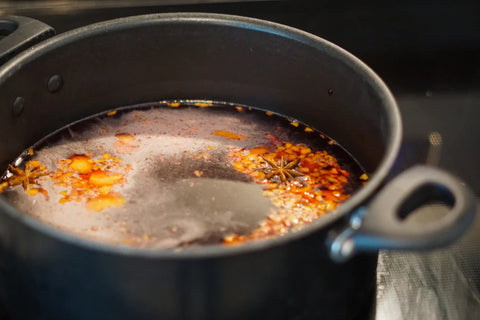 Simmering mulled wine ingredients together in a pot on a stovetop