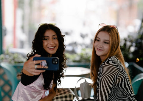 trendy friends taking a selfie with their iPhone 13