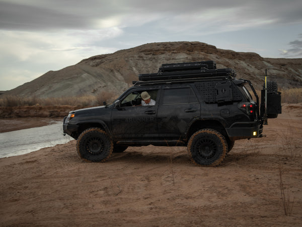 Hard top tent mounted to toyota 4Runner with overland mounts on top, maxtrax and roam cases