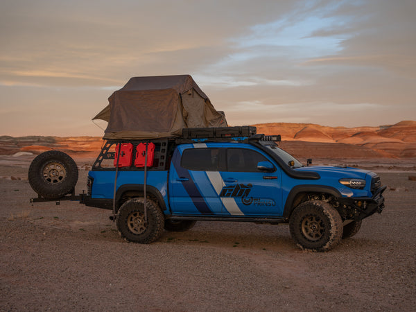 a photo of a soft top tent on top of a toyota tacoma in the utah desert. 