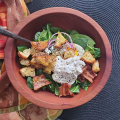 spinach salad in a wood bowl