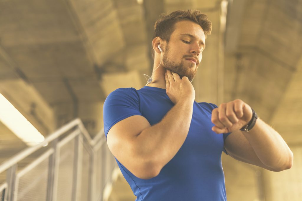 Man checking heart rate monitor on his fitness band 