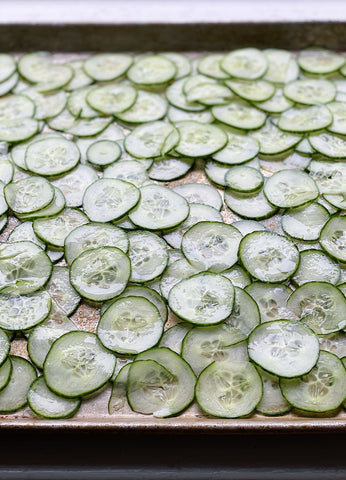 sliced cucumbers on a cooking sheet tray