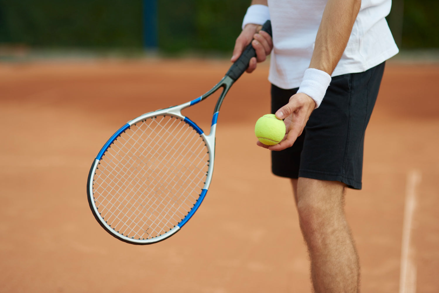Tennis Player Holding a Tennis Ball and Racquet