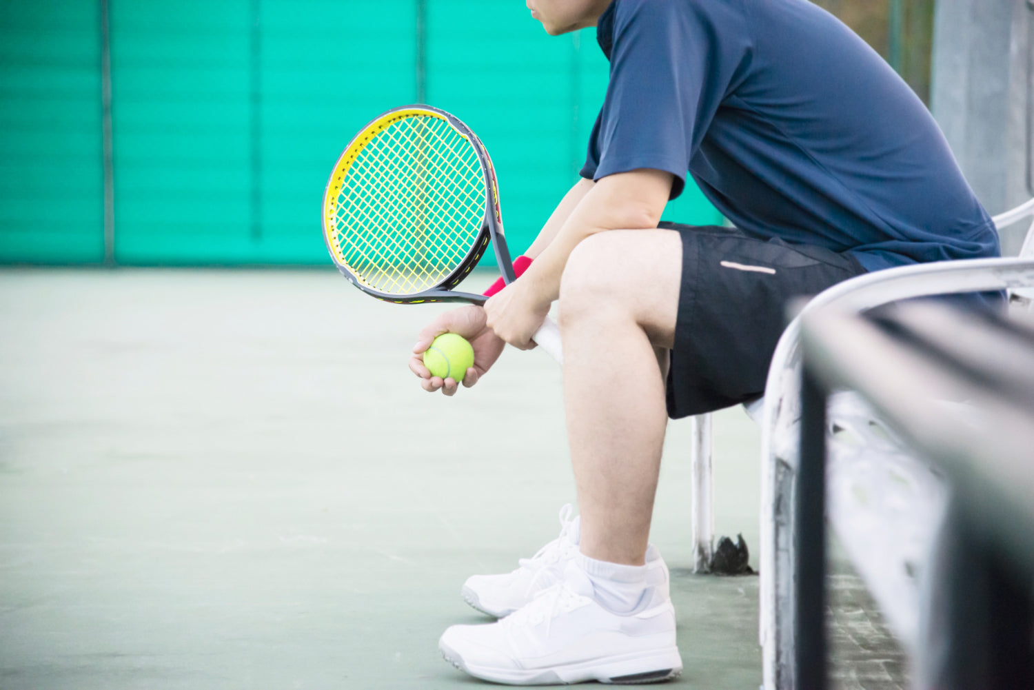 sad tennis player sitting in the court after lose a match