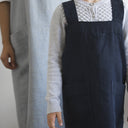 Child wearing Mini kids linen smock apron with adult behind wearing adult smock apron by Hemme