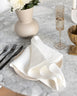 Oversized white linen napkin on marble table with flatware