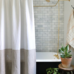 Spencer white and natural colour-blocked linen shower curtain hanging over bathtub 