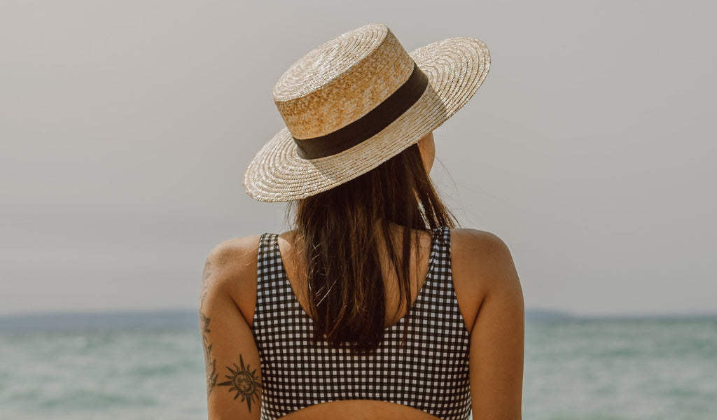 Mädchen mit Hut am Strand