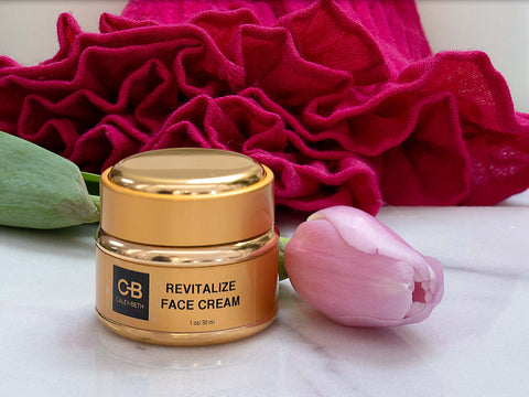 Crème Visage Revitalisée Caley-Beth à côté d'une tulipe rose.