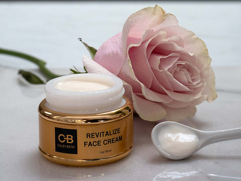 Caley-Beth Revitalize Face Cream next to a pink rose, and the light silky texture in a spoon.