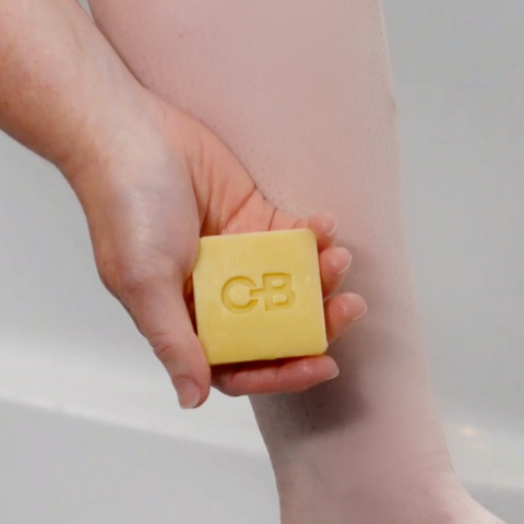 Applying Caley-Beth After Shave Balm Lotion Bar to leg.