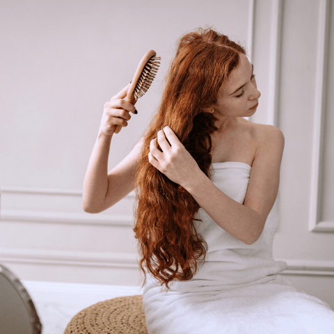 Femme qui se brosse les cheveux
