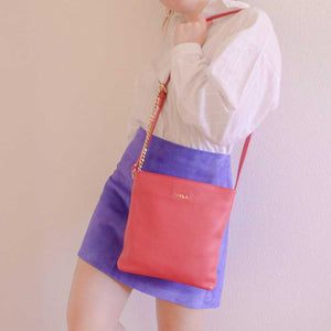 A raspberry pink bag with a blue skirt.