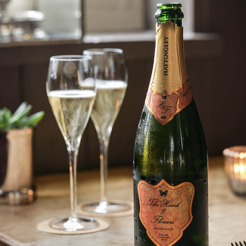 The Hand in Flowers sparkling wine by Hattingley Valley, open bottle and two flutes filled with sparkling wine