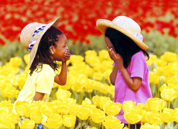 Photograph by Kelly Johnson of two girls full of joy and gratitude enjoying the tulips at the Wooden Shoe Tulip Farm, Woodburn, OR.