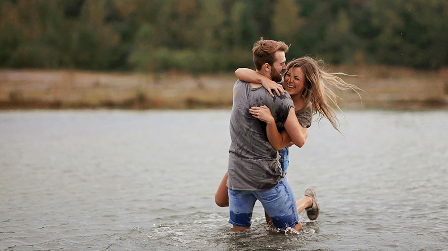 Couple playing around in the water, looking happy and in love