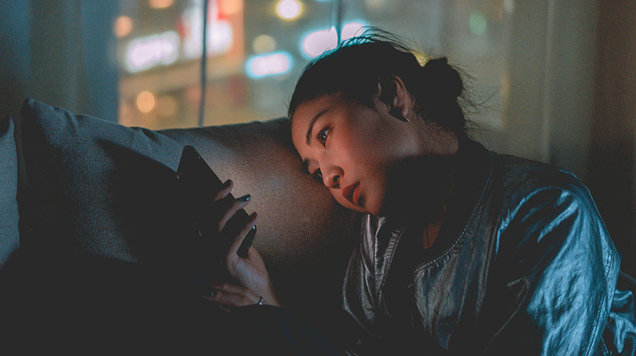 Woman looking at her phone screen in a dark room