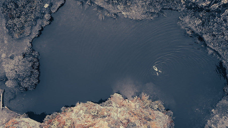 Person swimming in lake, drone photo from above