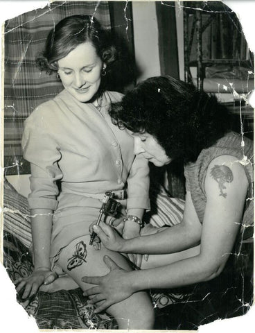 Female tattoo artist performing a tattoo
