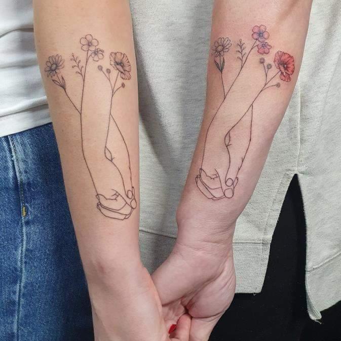 Linework tattoo of holding hands and flowers