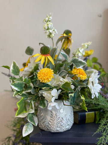 A yellow, white, and green faux flower arrangement