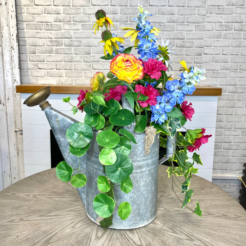 An artificial flower design in a vintage watering can