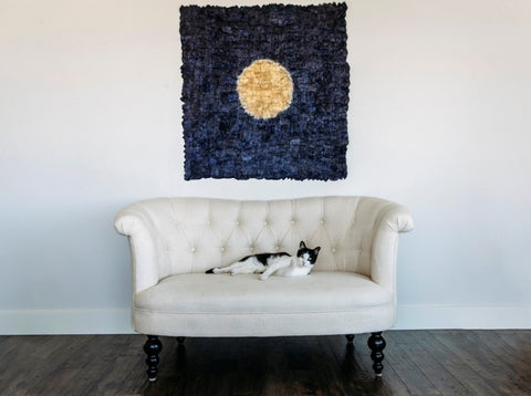 makira moon panel displayed behind couch with cat on it