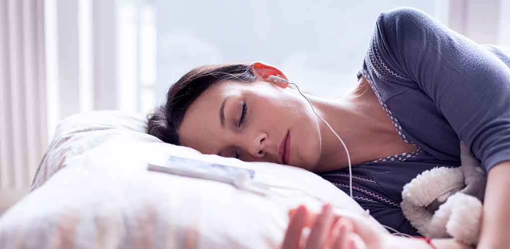 smartsleep Schlafmagazin: White Noise Geräusche zum Einschlafen Frau schläft besser mit Rauschen und Kopfhörern