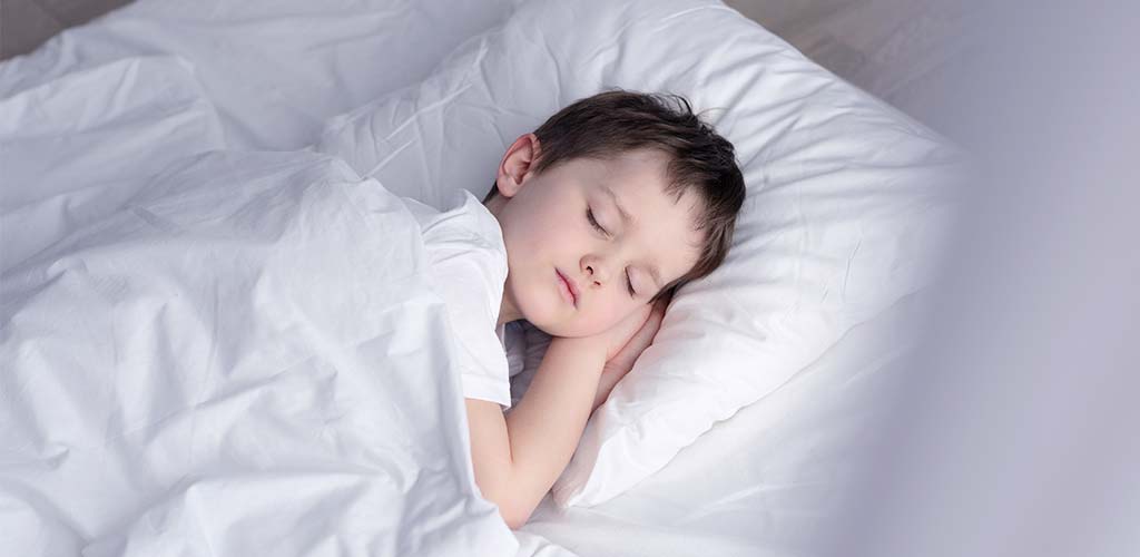 smartsleep Schlafmagazin Kleiner Junge schläft ruhig auf einem weichen Kopfkissen
