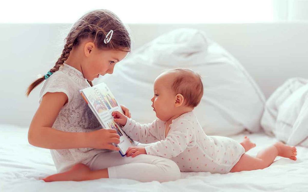 Baby und Kind lesen vor dem Schlaf im Bett