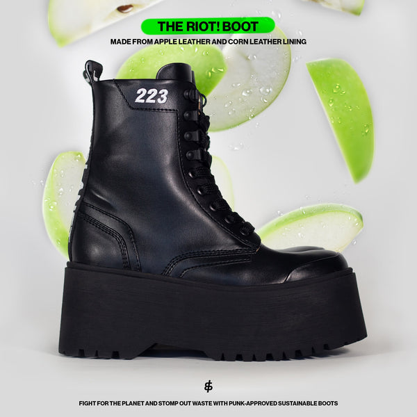 Visual of the chunky platform style goth rave boot - RIOT! with an all-black apple leather upper, with slices of apple falling in the background