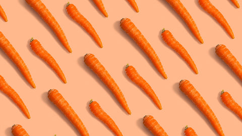 Pop art style fresh carrots lined up on a light orange background