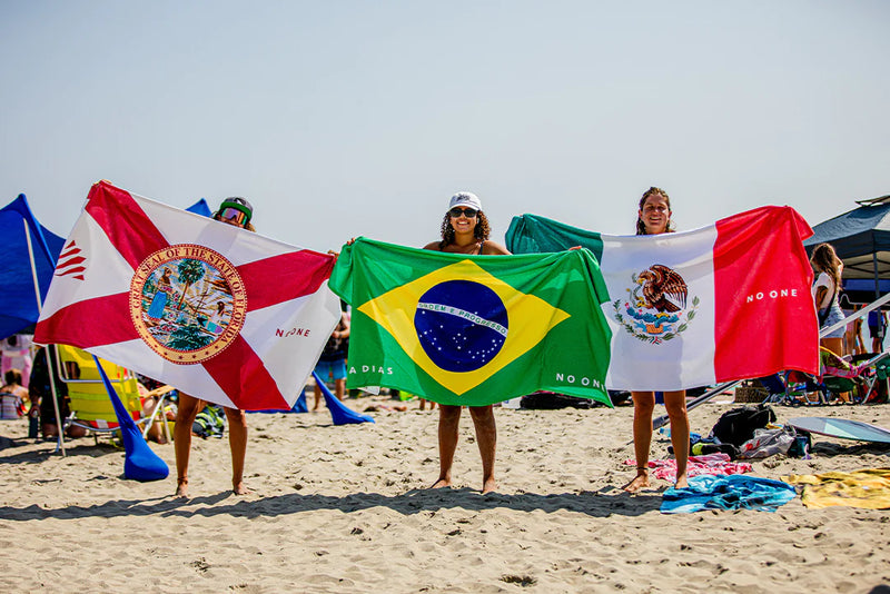 Skimboarders on the beach with flags