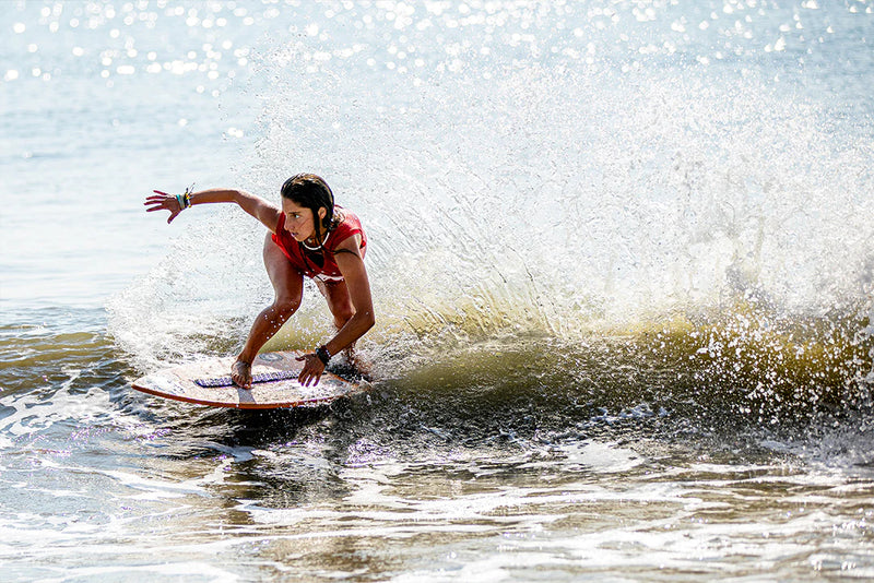 A female skimboarder on a wave
