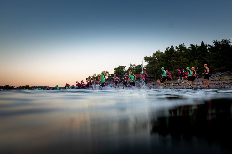 ÖTILLÖ competitors running into the water from the land in the early morning during the World Championships 2022