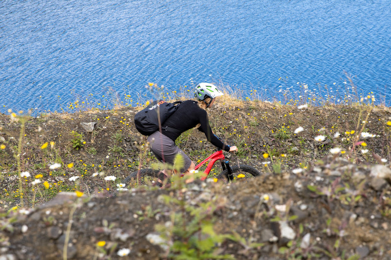 Mountain biker riding with a dryrobe® compression bag on her back