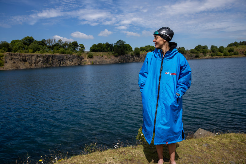 Joanna Shimwell stood by a lake in her dryrobe Advance and swim cap