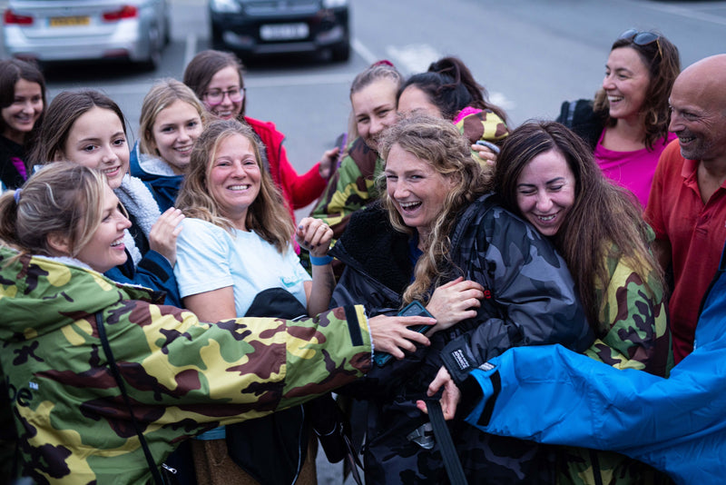 Seaful with a group of people wearing dryrobes and laughing