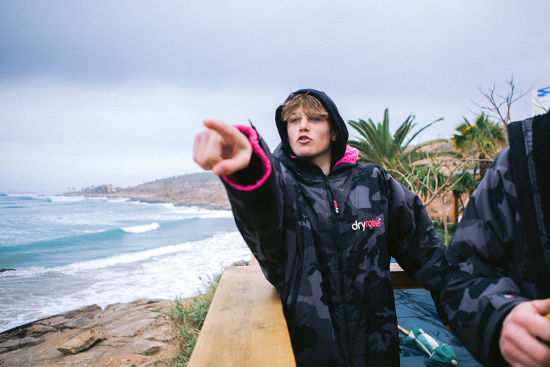 Lukas Skinner wearing a Black Camo Pink dryrobe Advance by the sea