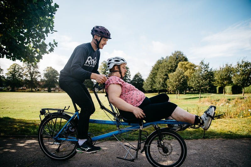 A RORO cyclist on a tandem bike with another cyclist 