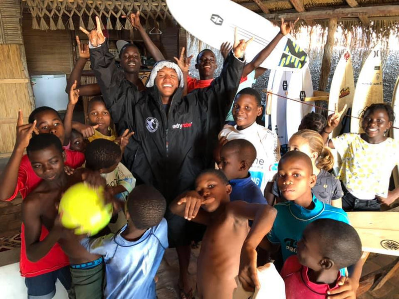 Mini Cho with kids on the Surfers Not Street Children progam wearing a dryrobe and his hands in the air 