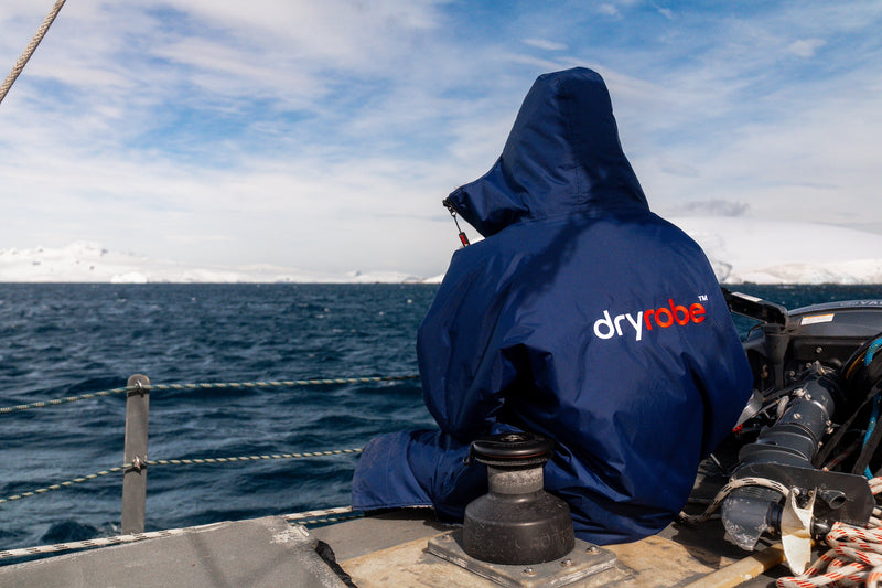 Person sat on the side of a boat in a dryrobe