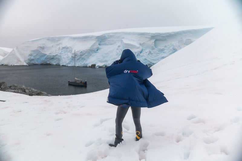 Person stood in the snow in Antartica wearing a navy dryrobe